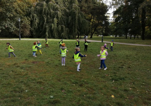 Dzieci na trawie w parku podczas spaceru bawią się krążkami